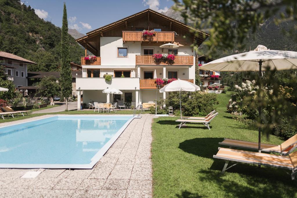 uma villa com piscina em frente a uma casa em Untermairhof em Lagundo