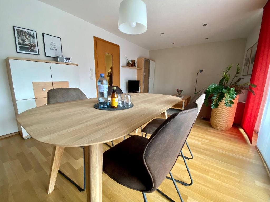 una mesa de madera y sillas en la sala de estar. en Ferienwohnungen Christine, en Dornbirn