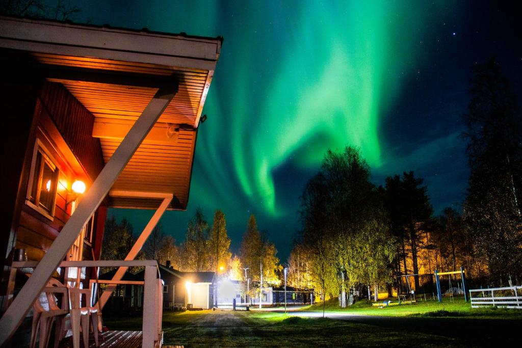 an image of the aurora borealis behind a building at Motelli Rovaniemi in Rovaniemi