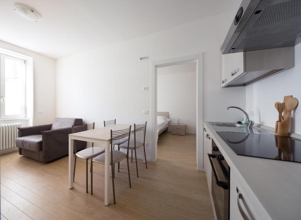 una cucina e un soggiorno con tavolo e sedie di I Dodici mesi - appartamento Primavera a Trento