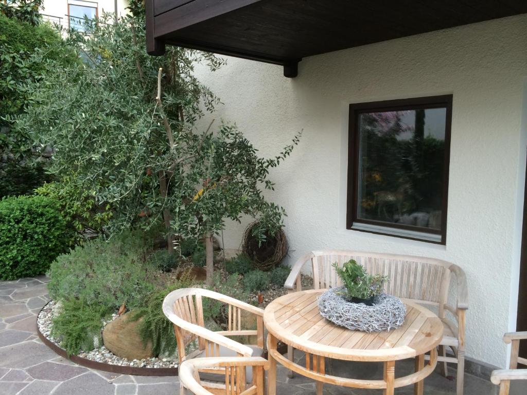 un patio con tavolo, 2 sedie, tavolo e sedie di Pension Hauenstein a Lagundo