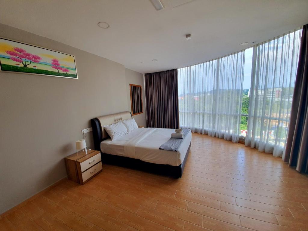 een slaapkamer met een bed en grote ramen bij Bangi Perdana Hotel in Bangi