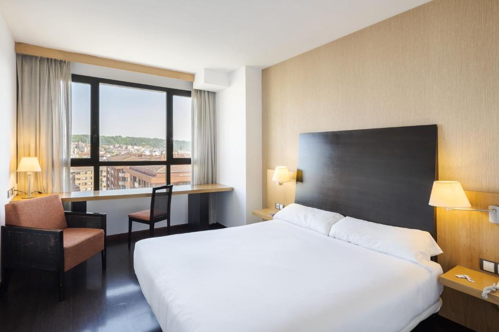 Una habitación de hotel con una cama grande y una ventana. en RICE Bulevar, en Burgos