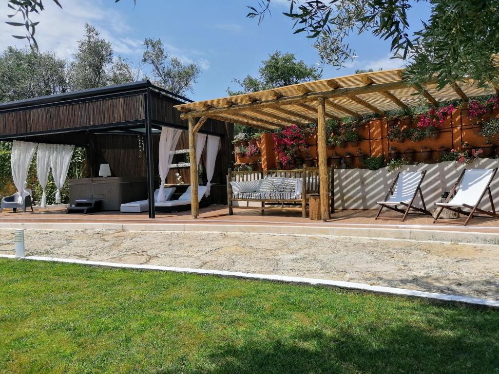 a pavilion with chairs and a bench in a yard at Quinta do Guerra in Boldrarias