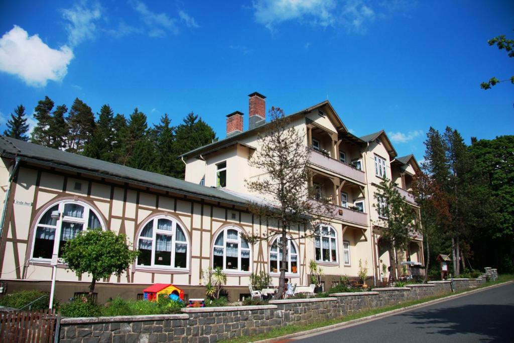 ein großes weißes Gebäude mit Fenstern auf einer Straße in der Unterkunft Pension Villa Kassandra in Altenau