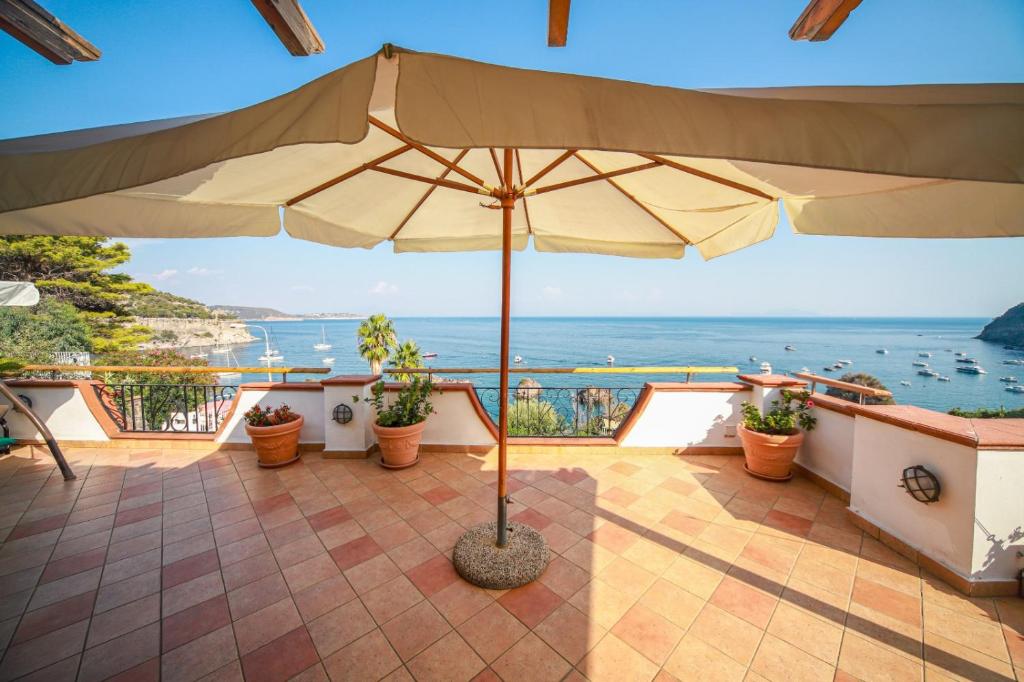 d'une terrasse avec un parasol et une vue sur l'océan. dans l'établissement Profumo di mare, à Ischia