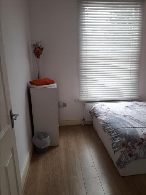 a bedroom with a bed and a window with a refrigerator at 03 Bedroom Apartment-Self Check in in London