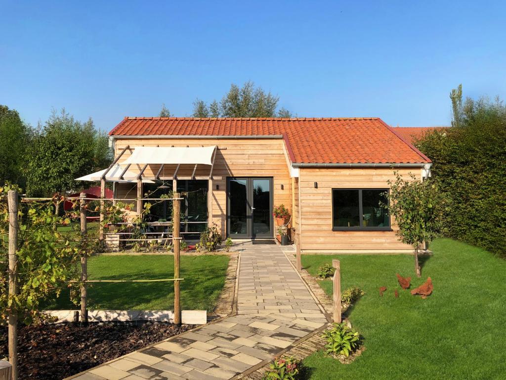 uma casa de madeira com um caminho que a conduz em Hoeve Altena Cottage em Woudrichem