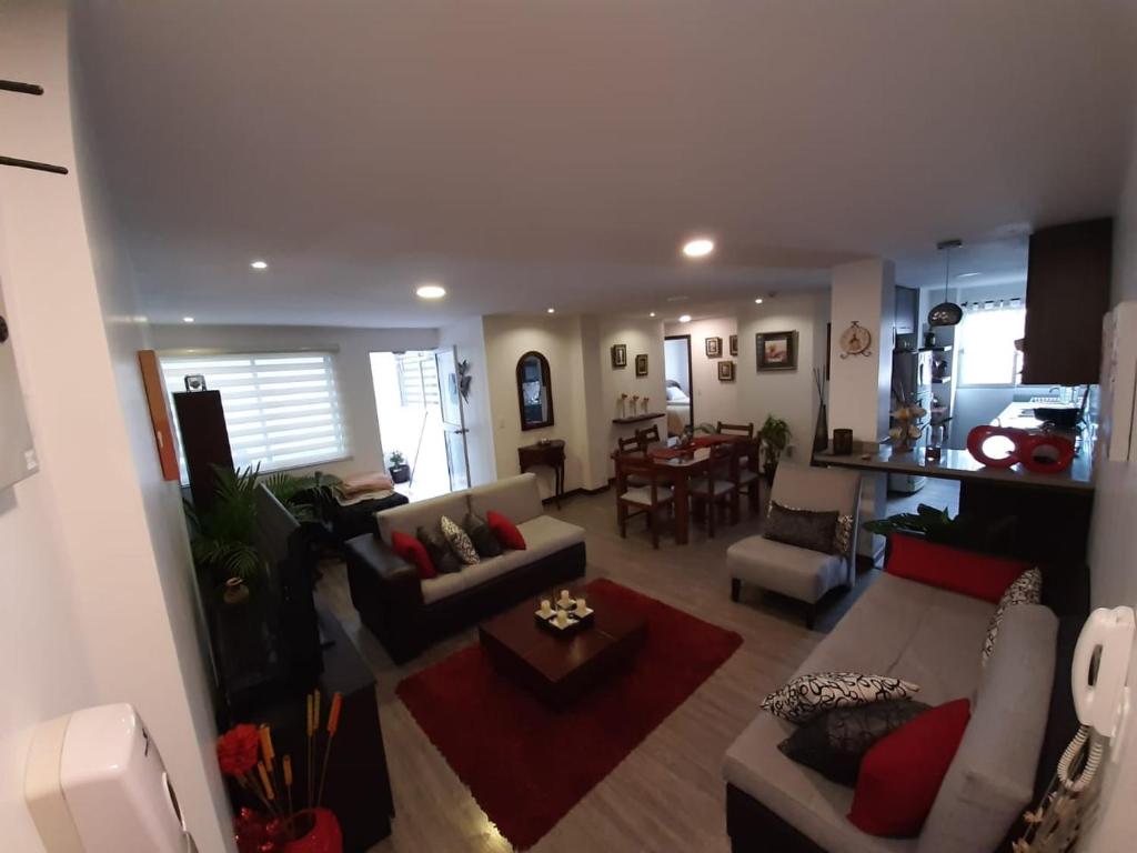 a living room with couches and a dining room at Moderno departamento en Condominio Providencia in Cuenca