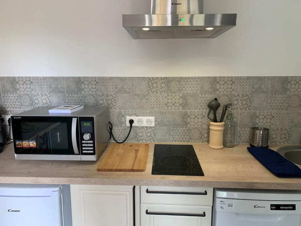 a microwave oven sitting on a counter in a kitchen at L&#39;Arbois 1876-La Verrière- in Arbois