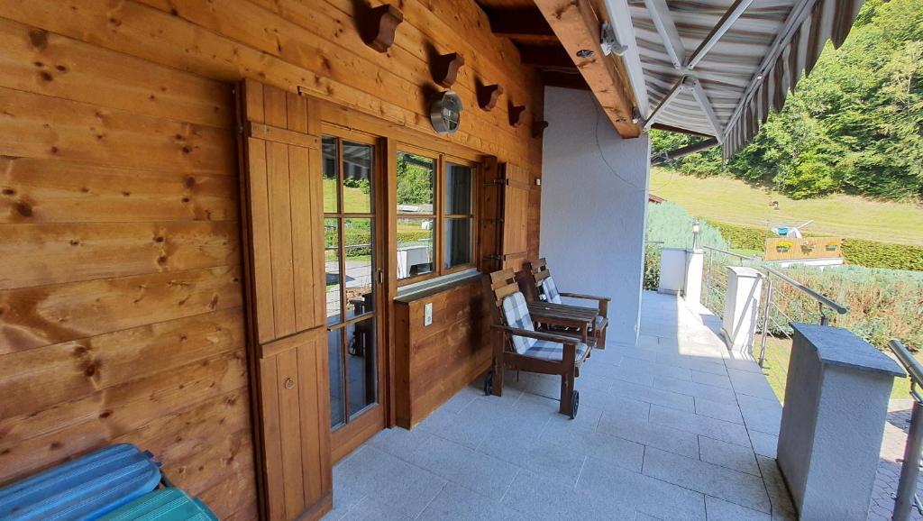 une terrasse couverte d'une maison en bois avec un mur en bois dans l'établissement Chalet Landhaus Einsiedler, à Sankt Gallenkirch