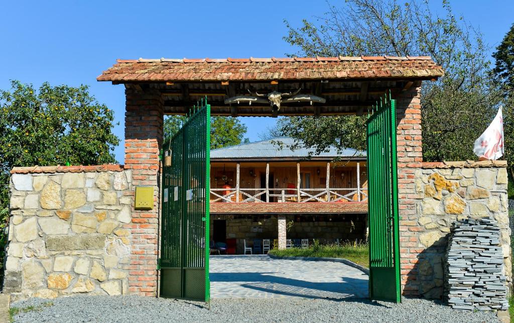 een stenen boog met een groene deur voor een gebouw bij Agro Guesthouse Korena in Koetaisi