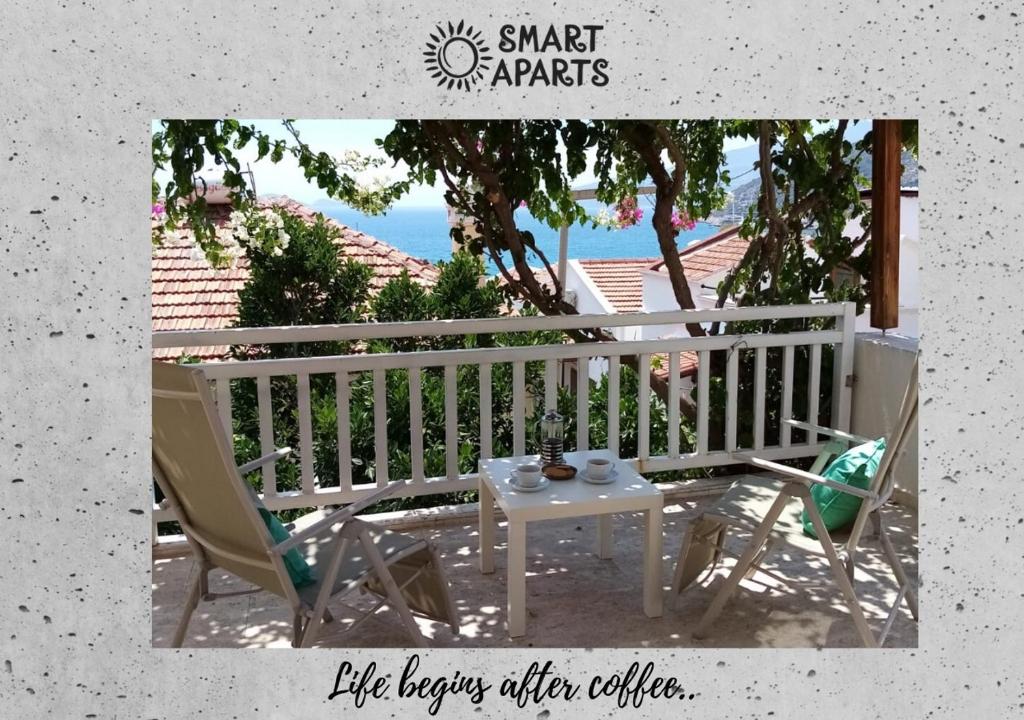 a porch with a table and chairs and the ocean at Smart Aparts in Kalkan