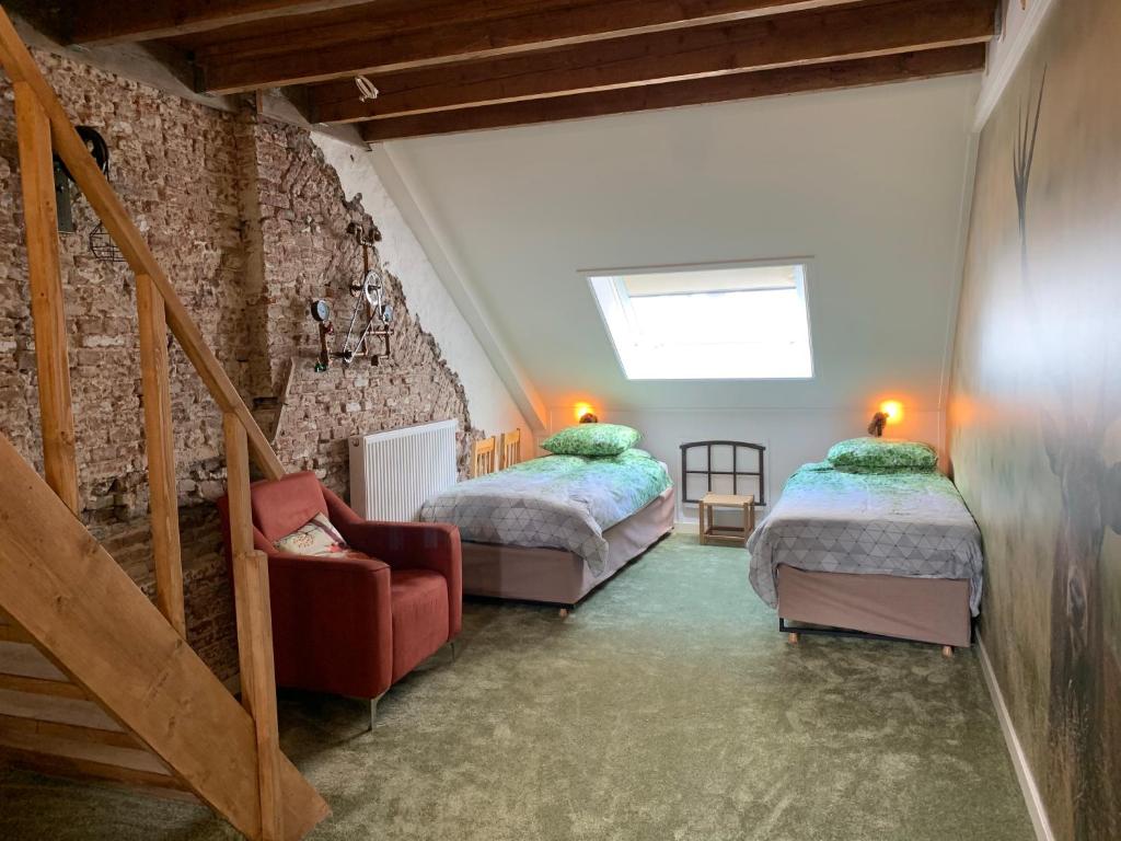 a attic room with two beds and a staircase at Logement Meijnerswijk Free Parking, Electric Parking, Centrally Situated in Arnhem