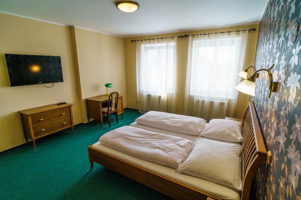 Postel nebo postele na pokoji v ubytování Hotel U Labutě