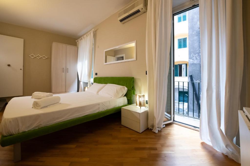 um quarto com uma cama e uma grande janela em Magenta Collection Crociferi 3 em Roma