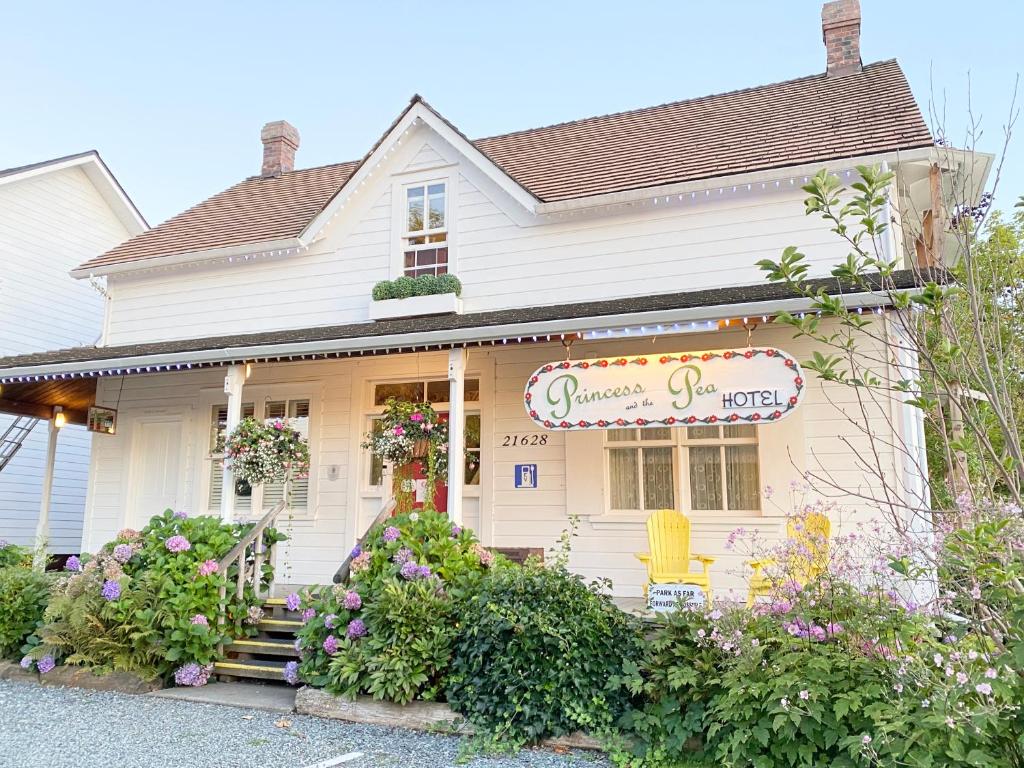 una casa blanca con flores delante en Princess and the Pea Hotel, en Langley