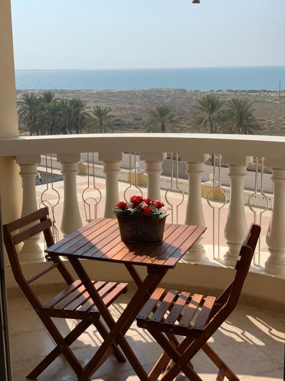 a table on a balcony with a basket of flowers at Wait N Sea !! Sea View Studio Ras Al Khaimah in Ras al Khaimah