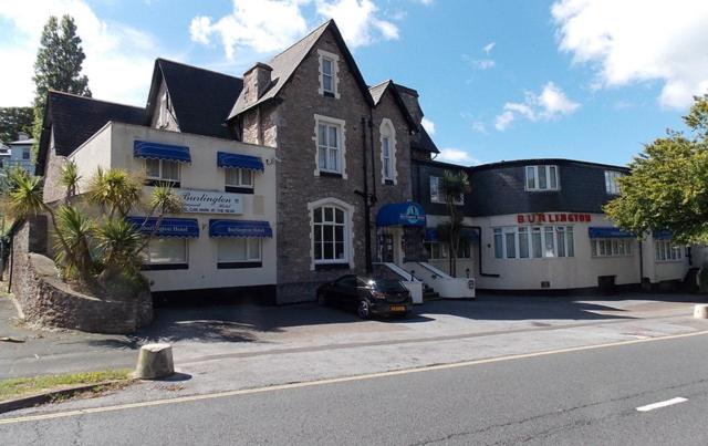 un edificio con un coche aparcado delante de él en The Burlington Hotel, en Torquay