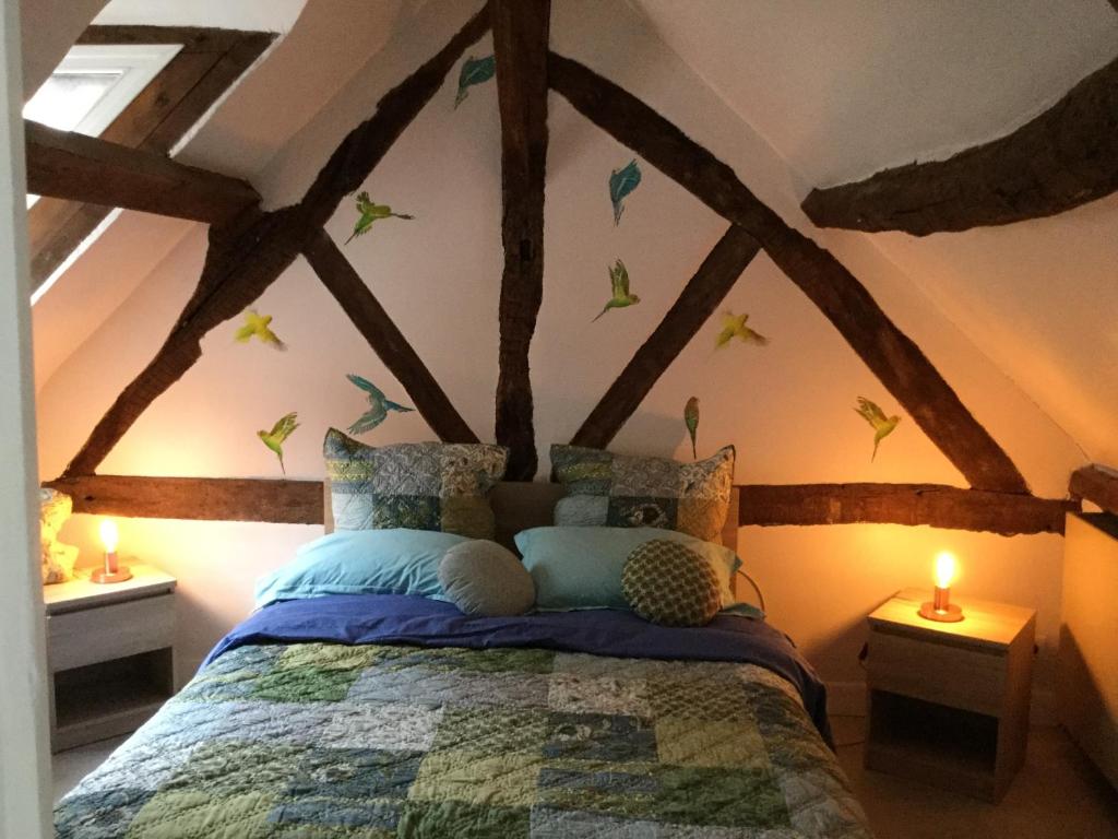 オンフルールにあるLes 4 lions duplex chic et charmeのベッドルーム1室(壁に鳥が描かれたベッド1台付)