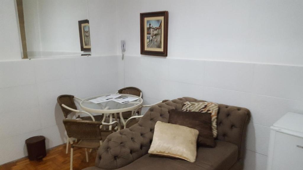 uma sala de estar com um sofá e uma mesa em Comodidade e Segurança no Centro em Belo Horizonte