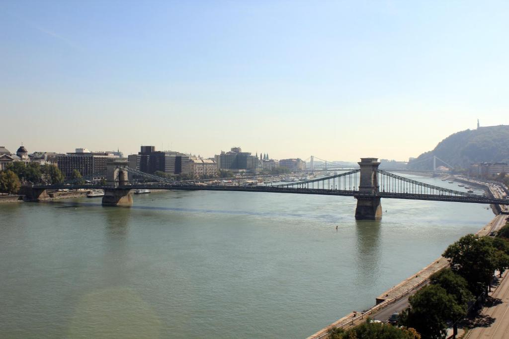 a bridge over a river with a city in the background at Boutique Hotel Victoria Budapest in Budapest