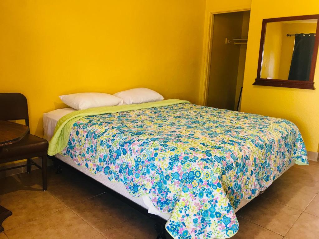um quarto com uma cama com um edredão colorido em Commodore Motel em Oakland