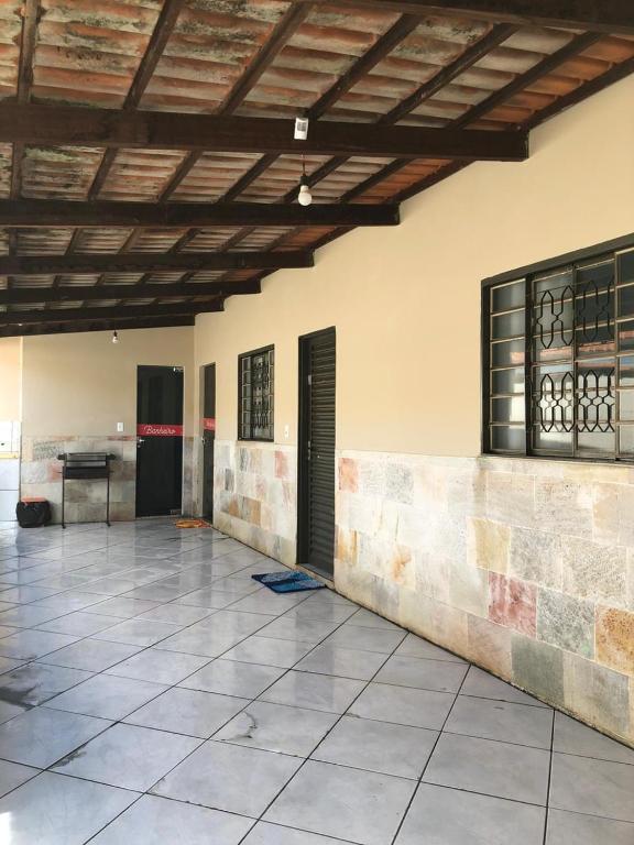 Habitación grande con suelo de baldosa y techo de madera. en Casinha Flor de Lis, en Pirenópolis