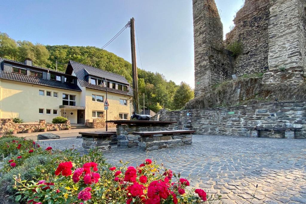 a picnic table and flowers in front of a building at Roosartige Ferien - Ferienwohnung am Weiherturm in Bacharach