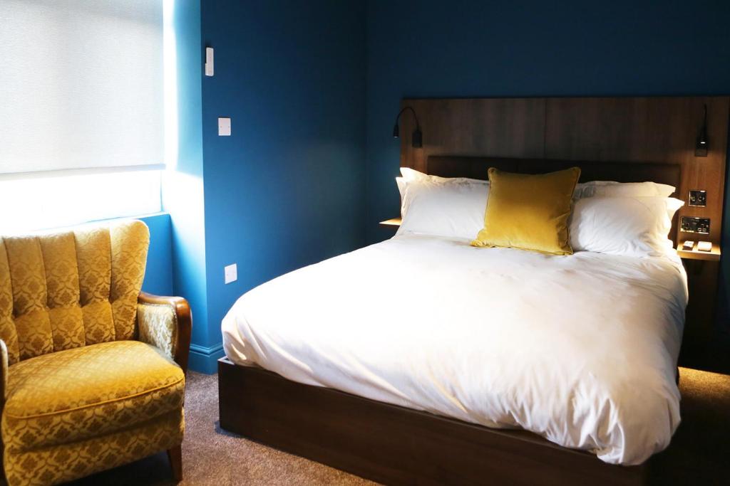 - une chambre avec un lit et une chaise dans l'établissement The Cherry Rooms, à Londres