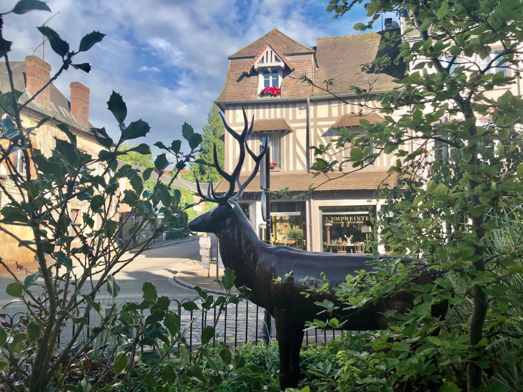 a statue of a deer in front of a building at Gite Hotel de maître centre village la Chapelle in Lyons-la-Forêt