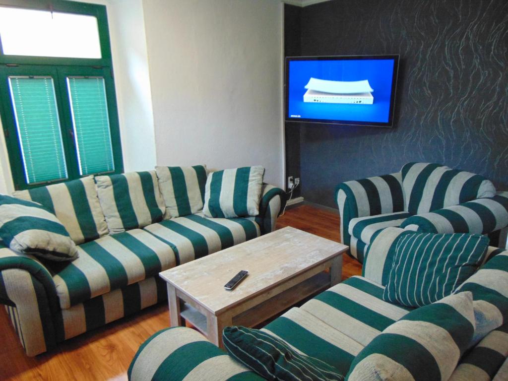 a living room with two couches and a tv at FerienAppartement NO.18 in Sangerhausen