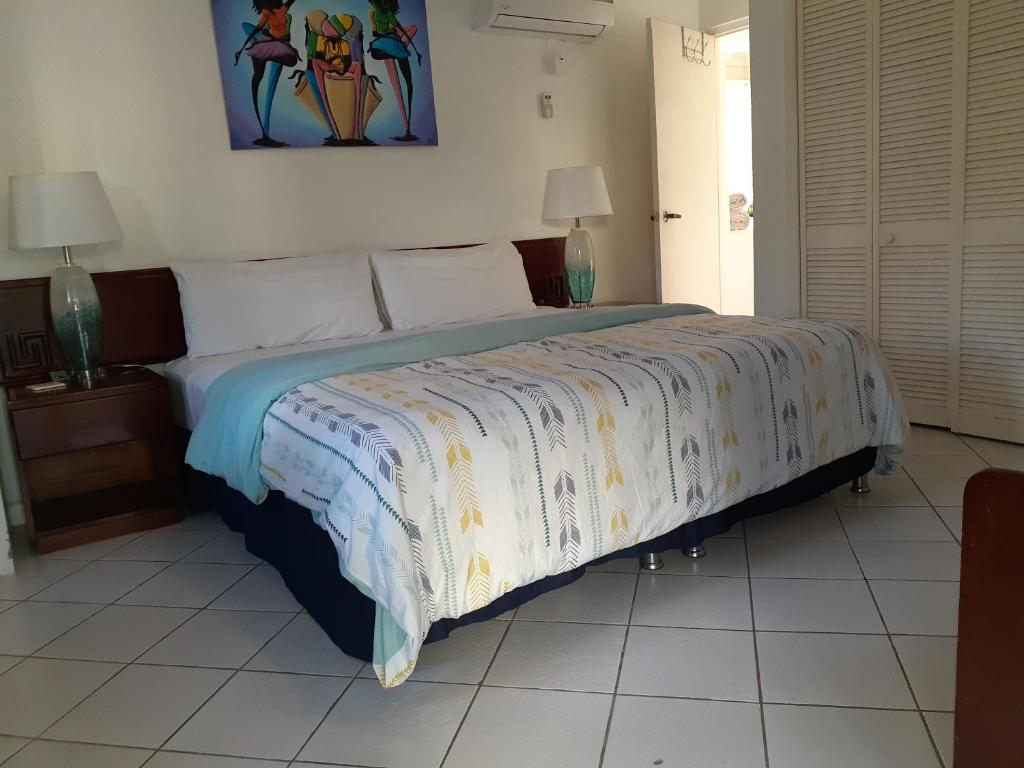 a bedroom with a large bed with a blanket on it at Zander's Paradise @Mystic (King) in Ocho Rios