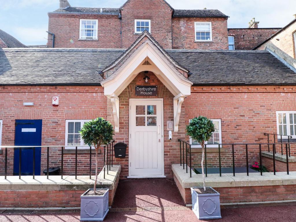 a red brick building with a white door at Beresford Dale in Ashbourne