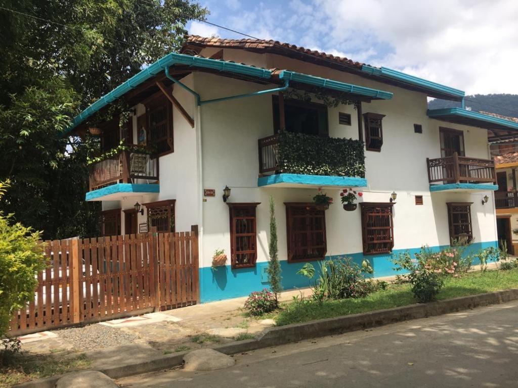 Casa Huespedes EL ENSUEÑO في خاردين: منزل أبيض وأزرق مع سور خشبي