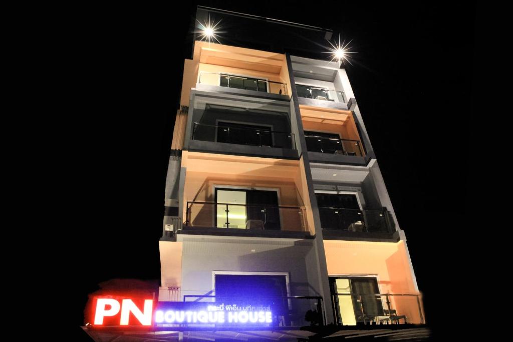 a tall building with a sign in front of it at night at Krabi P.N. Boutique House in Krabi town