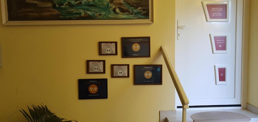 a wall withaques on a wall with a painting at Szlavi Apartman in Baja