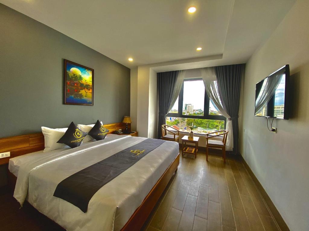 a bedroom with a large bed and a table at Royal Khanh Hotel in Tuy Hoa