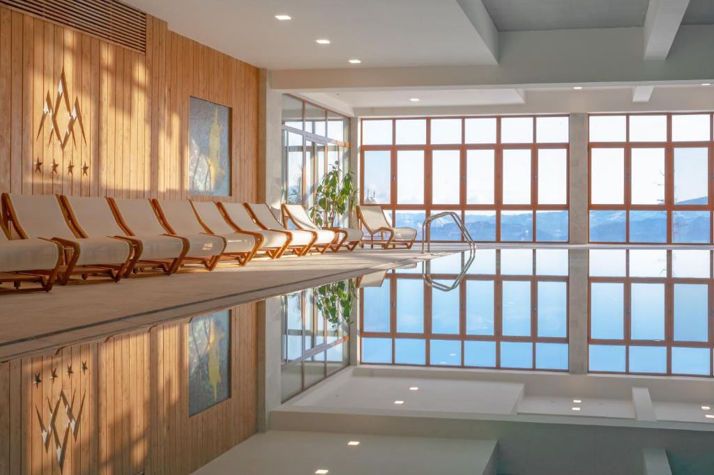 a row of chairs in a room with windows at Grand Hotel BELLEVUE in Vysoke Tatry - Stary Smokovec