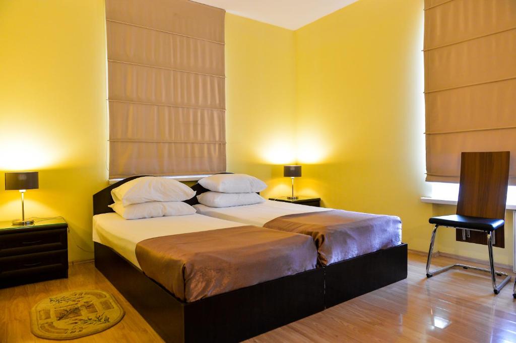 a bedroom with a bed with yellow walls and two lamps at Imereti Health Resort in Tskaltubo