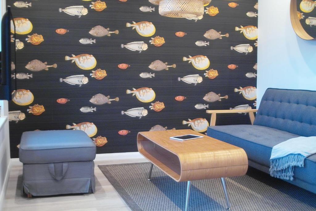 a room with a blue couch and a wall with shells at Design Ferienhaus am Plöner See Nahe der Ostsee in Bosau