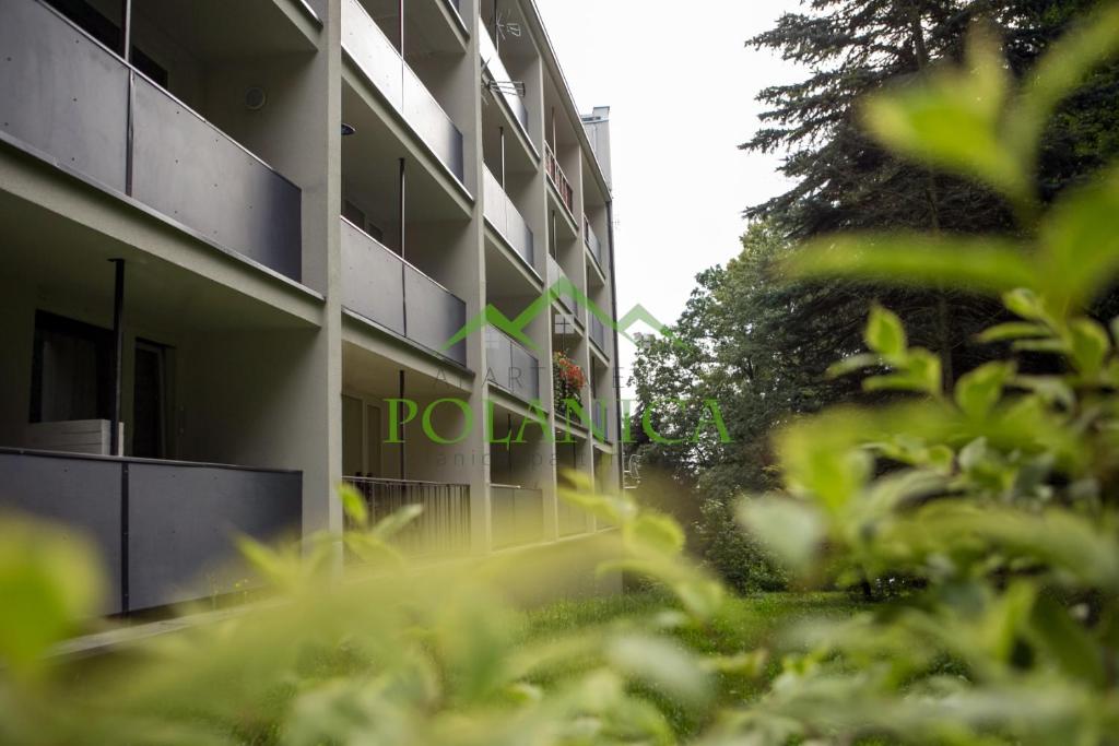 an external view of a building with trees in the foreground at Apartamenty w Parku Leśnym ul Cicha 1 - PolanicaApartamenty pl in Polanica-Zdrój