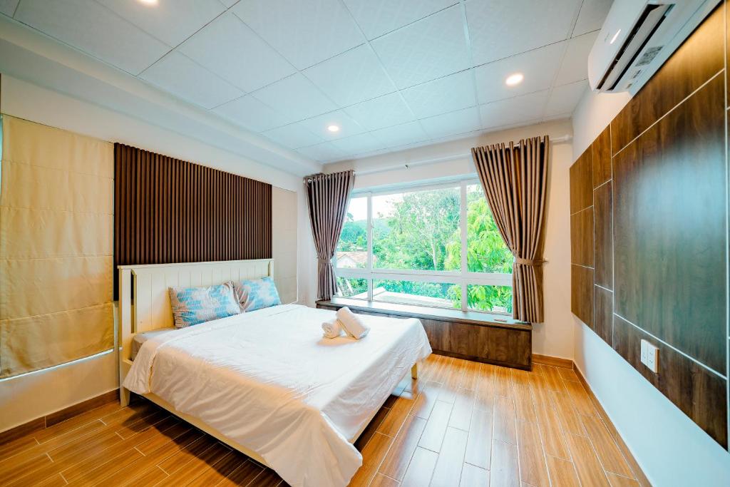 a bedroom with a bed and a large window at Kien Vang Bungalow in Phu Quoc