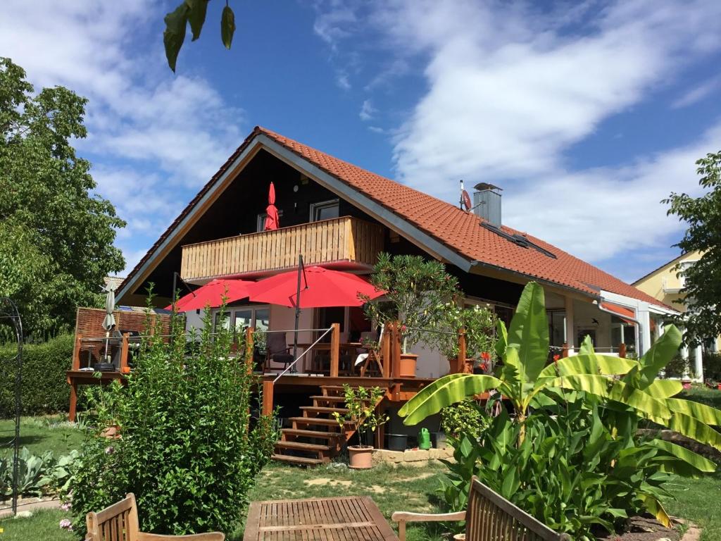 ein Haus mit einem roten Regenschirm davor in der Unterkunft FeWo Wipperhausen in Moos