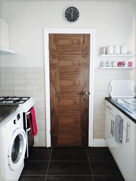 a kitchen with a washer and a wooden door at Richmond Luxury flat Fabulous location in Southend-on-Sea