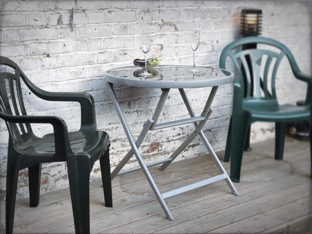 a table and two chairs next to a brick wall at Richmond Luxury flat Fabulous location in Southend-on-Sea