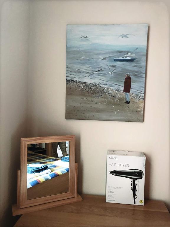 a mirror sitting on a table next to a painting at Richmond Luxury flat Fabulous location in Southend-on-Sea