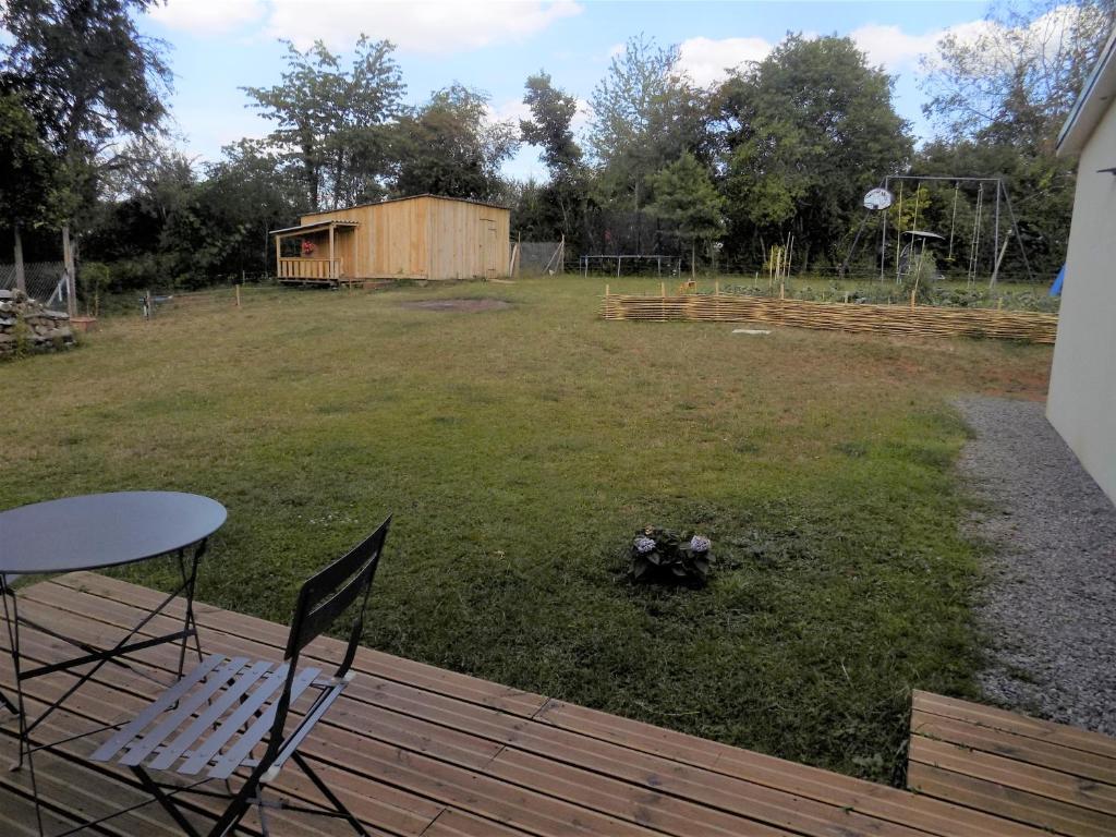 une terrasse avec une table et des chaises dans la cour dans l&#39;établissement Chambres d&#39;hôtes à Raveau, à Raveau