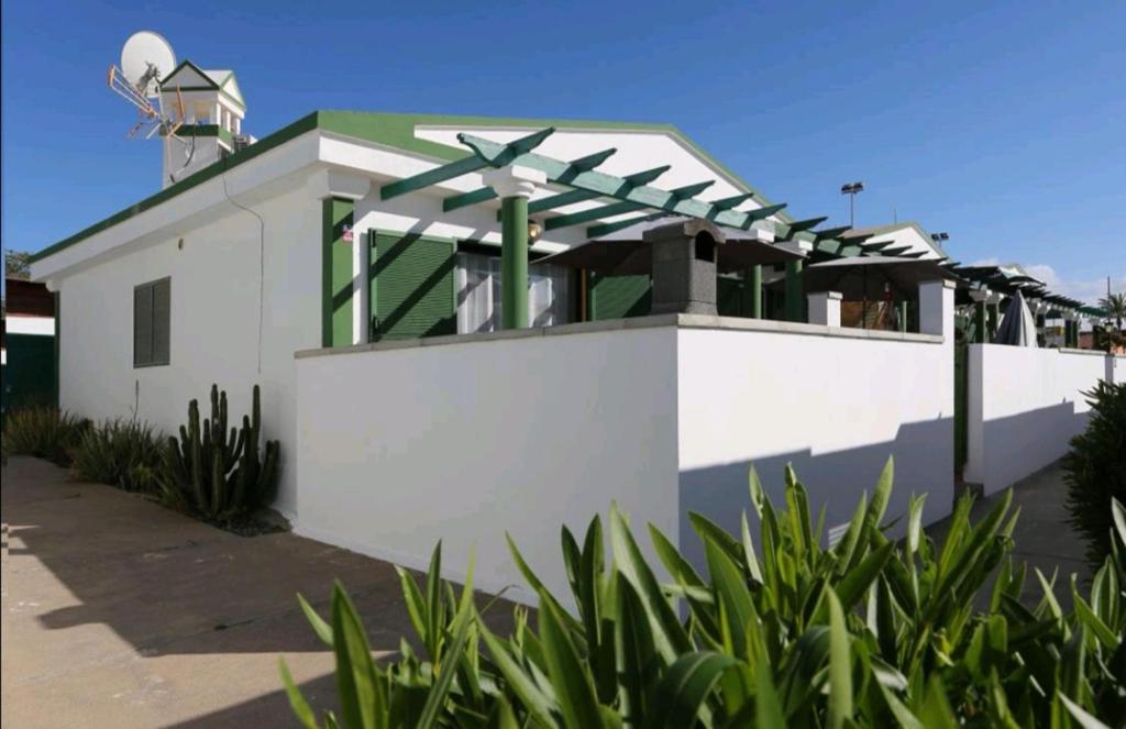 a white building with a green roof with a satellite at Vistagolf Maspalomas in Maspalomas