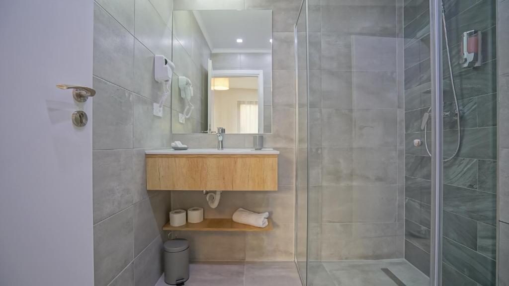 a bathroom with a shower and a sink and a mirror at Monarch House in Braşov